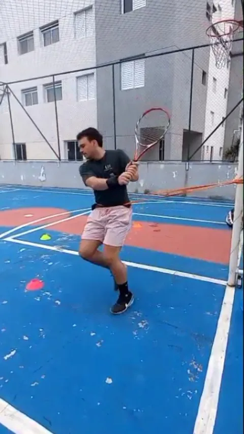 Atleta de tênis treinando agilidade em quadra na fase final da reabilitação de ombro e cotovelo